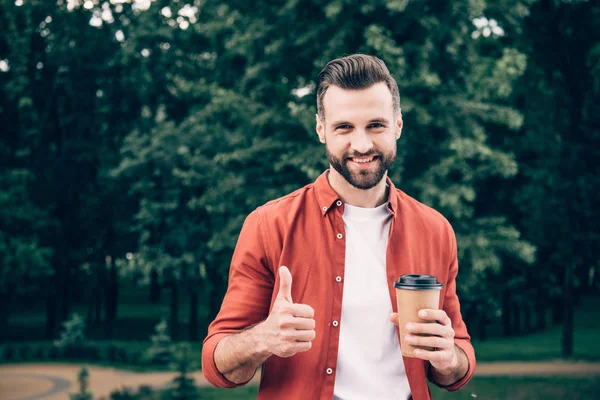 Ung Man Håller Kaffe För Att Och Visa Tummen Upp — Stockfoto