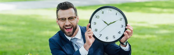 Imagem Panorâmica Empresário Olhando Para Câmera Sorrindo Apresentando Relógio — Fotografia de Stock