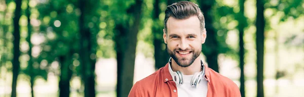 Plano Panorámico Del Hombre Con Auriculares Sonriendo Mirando Cámara —  Fotos de Stock