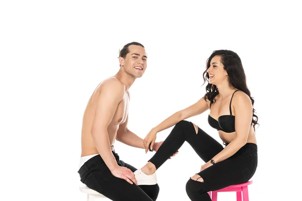 性感的微笑夫妇在黑色裤子坐在椅子上孤立白色 — 图库照片