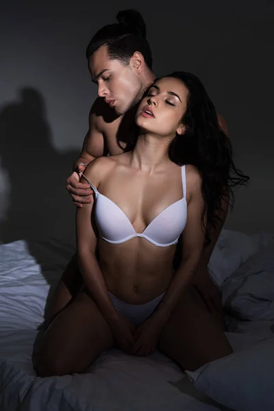 Koyu Yatak Odasında Yatakta Otururken Gömleksiz Adam Soyunma Seksi Kız — Stok fotoğraf