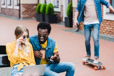 yakışıklı afro-amerikan adam yakın dizüstü bilgisayar kullanarak mutlu kadının seçici odak 