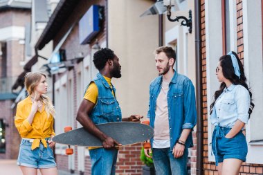 yakışıklı çok kültürlü erkekler çekici kızların yanında dururken konuşuyor 