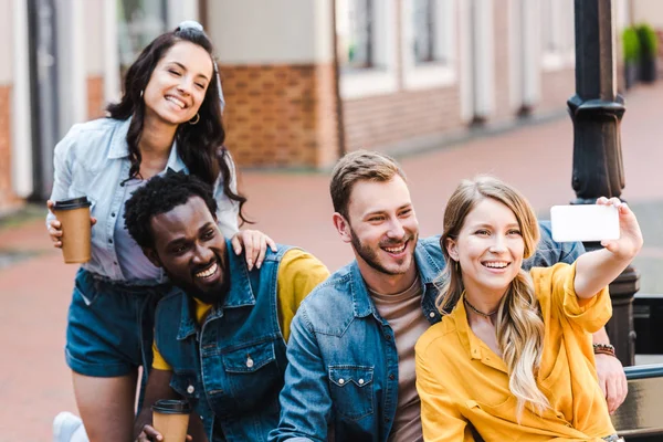 Amigos Multiculturais Felizes Olhando Para Smartphone Enquanto Toma Selfie — Fotografia de Stock