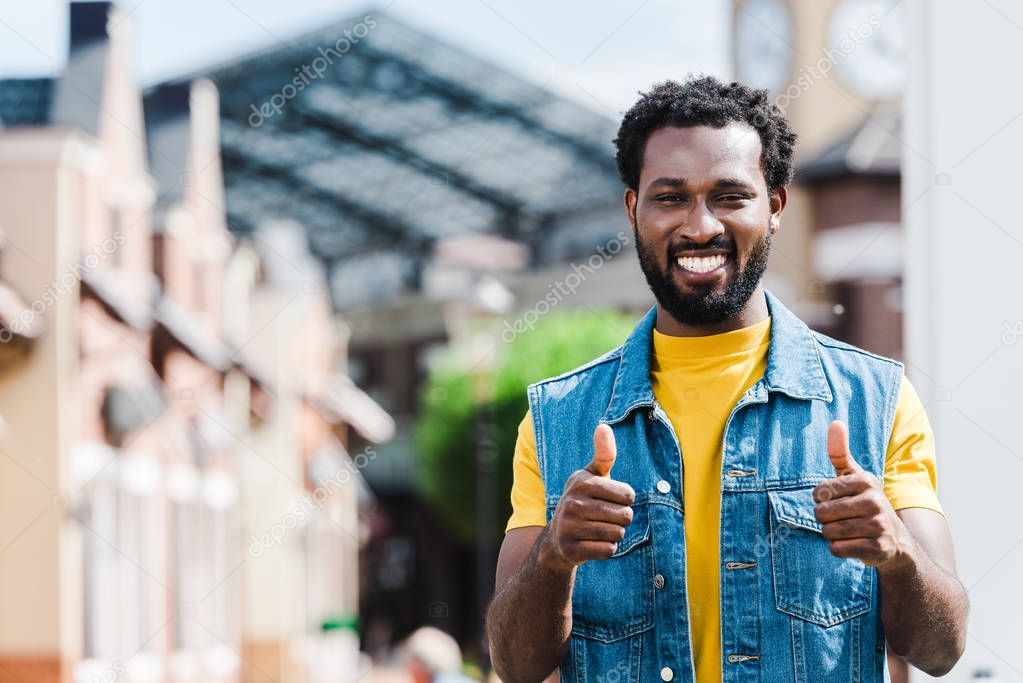 cheerful african american man showing thumbs up while looking at camera  