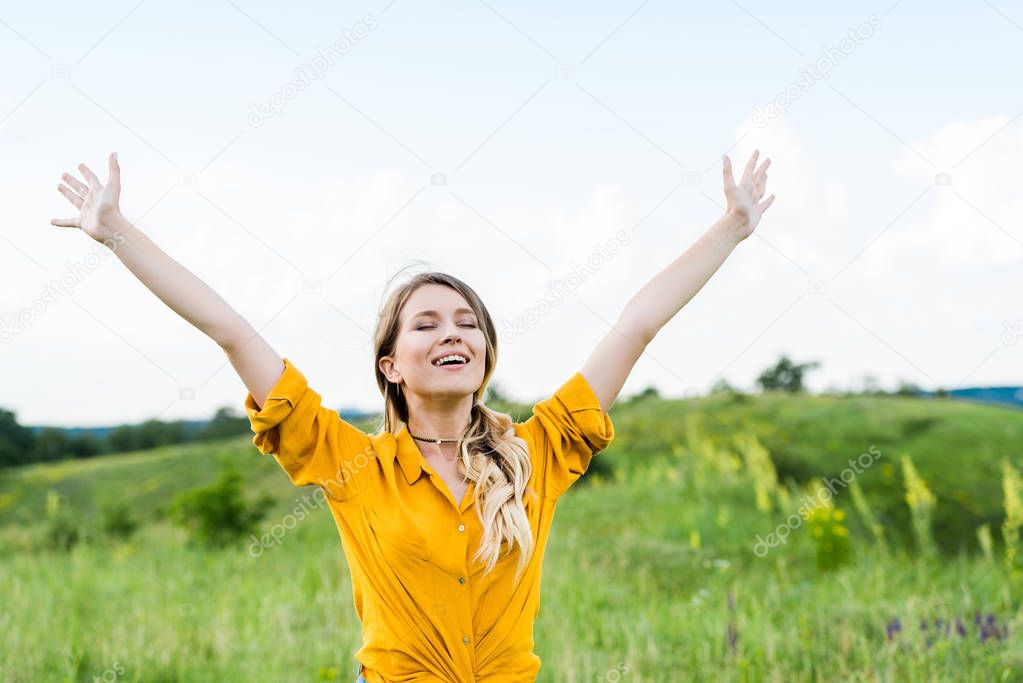 happy young woman with outstretched hands and closed eyes 