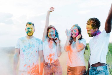 yüzleri holi boyalar ile çok kültürlü arkadaşlar yakın gesturing mutlu kadın 