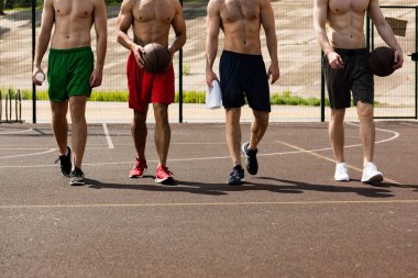 basketbol sahasında topları ile dört gömleksiz basketboloyuncuları kırpılmış görünümü