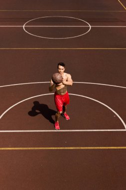 basketbol sahasında topu ile seksi gömleksiz karışık yarış basketboloyuncusu havai görünümü