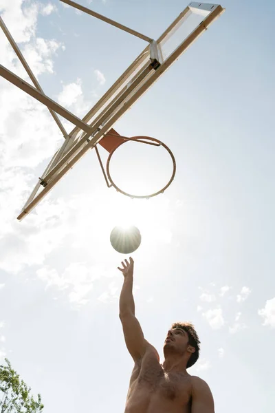 Güneşli Bir Günde Sepette Topu Atan Gömleksiz Basketbolcu Alt Görünümü — Stok fotoğraf