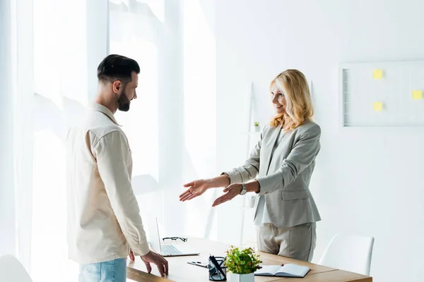 Gelukkig Blonde Recruiter Gebaren Office Buurt Van Knappe Bebaarde Man — Stockfoto