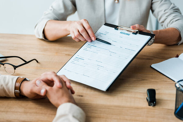 Обрезанный вид вербовщика, держащего ручку и буфер обмена рядом с мужчиной
 