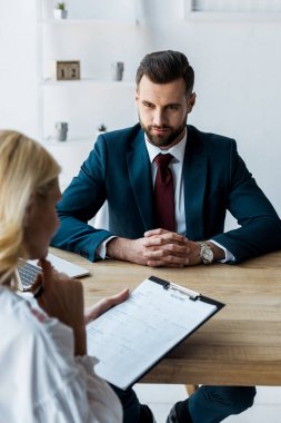 klonlu kadın bakarak sıkıştırılmış elleri ile sakallı İşveren seçici odak 