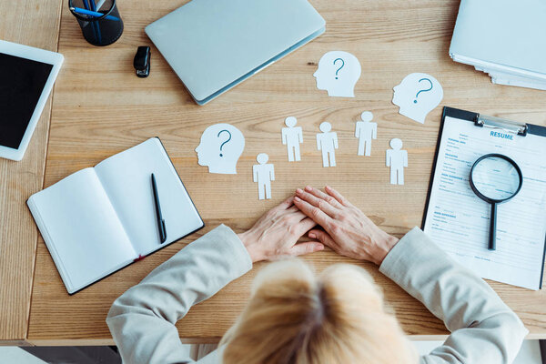 Вид сверху женщины рядом с бумагами и блокнотом на столе
 