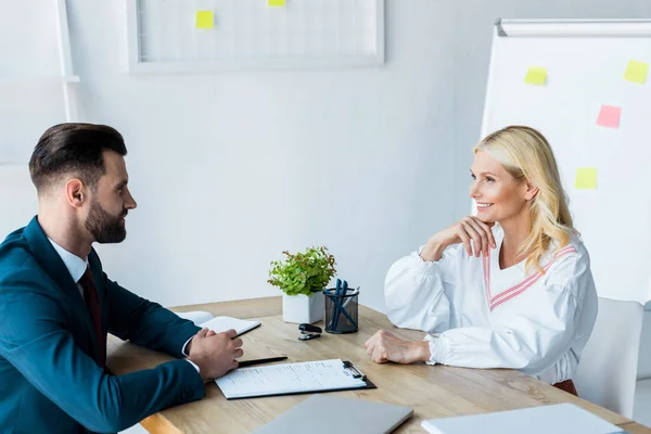 Lycklig Blond Kvinna Tittar Stilig Rekryterare Med Knuten Händer — Stockfoto