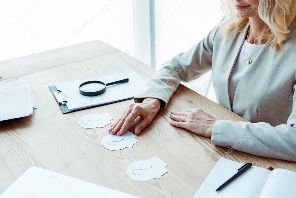 cropped view of recruiter near paper with question marks on table 