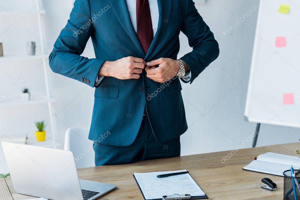 cropped view of recruiter touching formal wear in office
