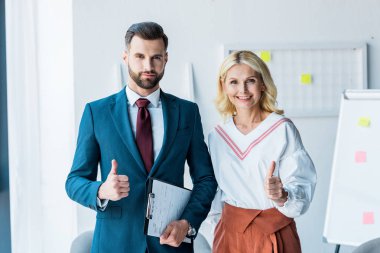 handsome recruiter and blonde woman showing thumbs up in office  clipart