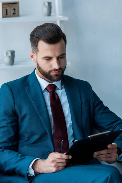 Handsome Bearded Recruiter Sitting Looking Clipboard — Stock Photo, Image