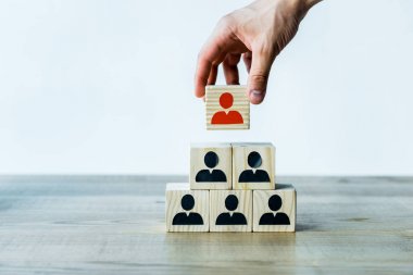 cropped view of man holding wooden cube near wooden desk  clipart