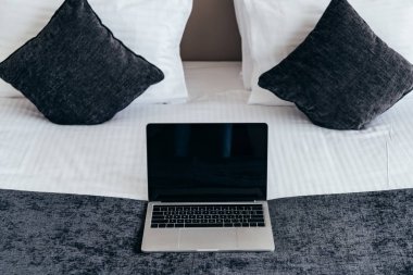 laptop with blank screen on bed in hotel room clipart