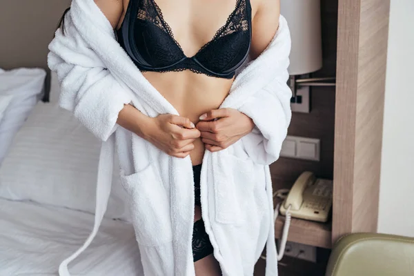 寝室の下着と白いバスローブのセクシーな女性の部分的なビュー — ストック写真