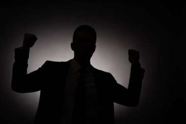 black silhouette of businessman showing yes gesture with back light clipart