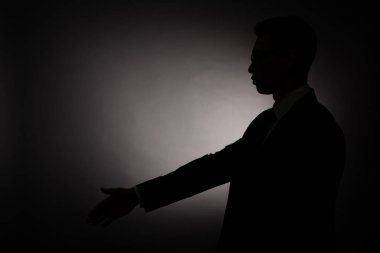 arka ışık ile tebrik jesti yapan işadamısiyah siluet yan görünümü