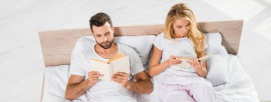 evde kitap ile yatakta yatan güzel çift panoramik çekim 