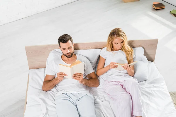 Vista Alto Ângulo Belo Casal Deitado Cama Com Livros Casa — Fotografia de Stock