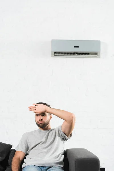 Homem Bonito Sentado Sofá Sofrendo Calor Sob Condicionado Casa — Fotografia de Stock