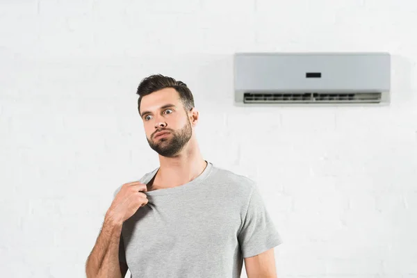 Knappe Man Lijdt Aan Warmte Onder Air Conditioner Thuis — Stockfoto