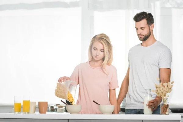 Donna Versando Cereali Ciotola Durante Colazione Vicino All Uomo Cucina — Foto Stock