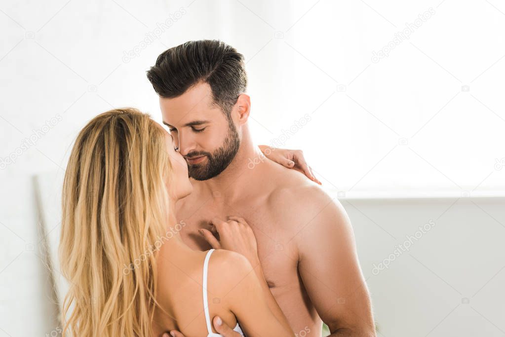 romantic young couple looking at each other and hugging at home in morning