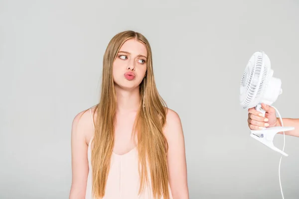 Hermosa Joven Mujer Haciendo Pucheros Labios Mirando Ventilador Eléctrico Aislado — Foto de Stock