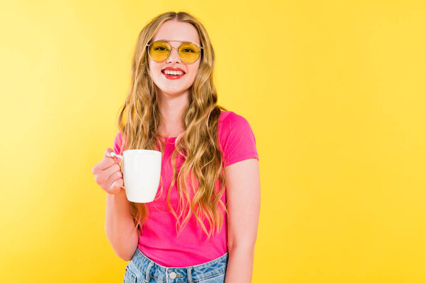 beautiful smiling girl in sunglasses with coffee cup Isolated On yellow 