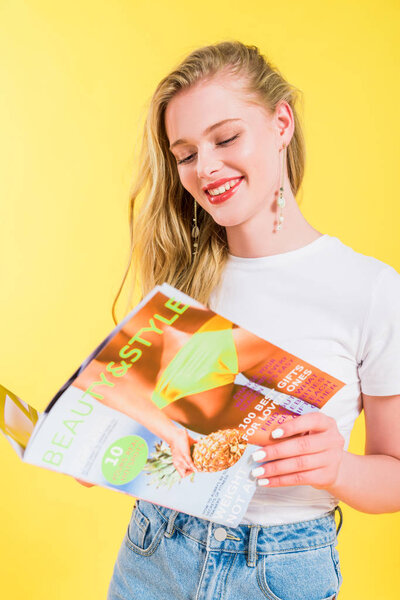 beautiful girl reading beauty and style magazine Isolated On yellow