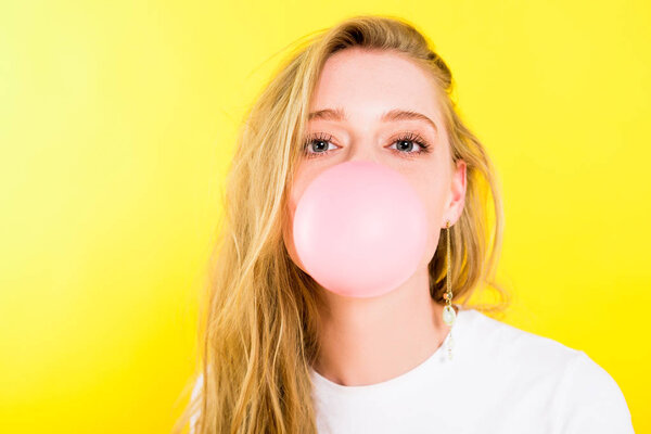beautiful girl blowing bubble gum Isolated On yellow