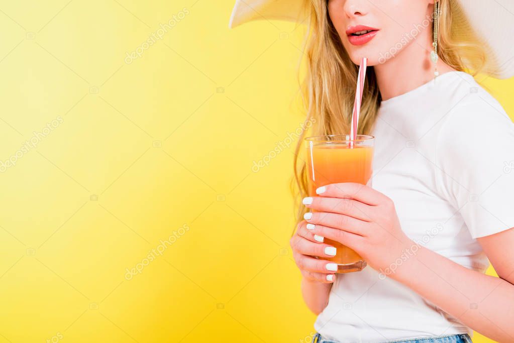 cropped view of blonde girl with cocktail glass On yellow