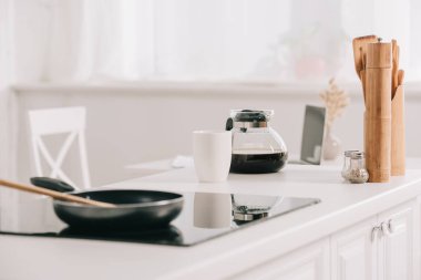 kahve pot ve fincan yakın pişirme yüzeyi üzerinde tava ile mutfak masası