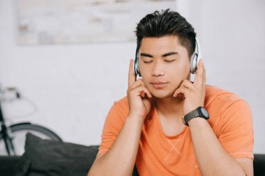 kapalı gözleri ile kulaklıklar içinde rüya Asya adam dinleme müzik