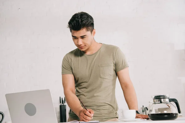 Guapo Asiático Hombre Mirando Portátil Mientras Pie Cerca Cocina Mesa — Foto de Stock