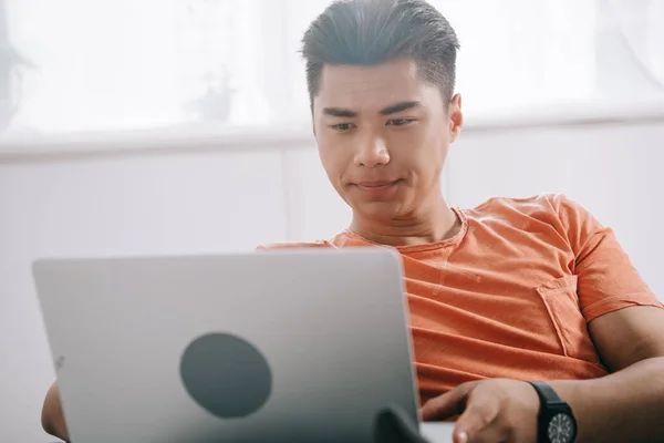 Allvarlig Asiatisk Man Med Hjälp Laptop Medan Sitter Soffan Hemma — Stockfoto