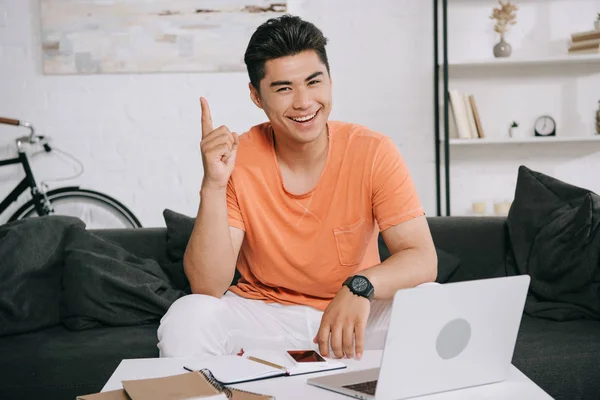 Cheerful Asian Man Looking Camera Showing Idea Sign While Sitting — Stock Photo, Image