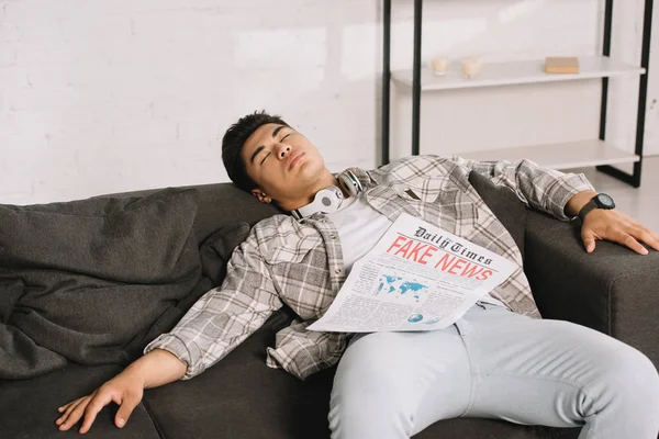 Zmęczony Asian Mężczyzna Spanie Kanapie Domu Fałszywym Gazety News — Zdjęcie stockowe