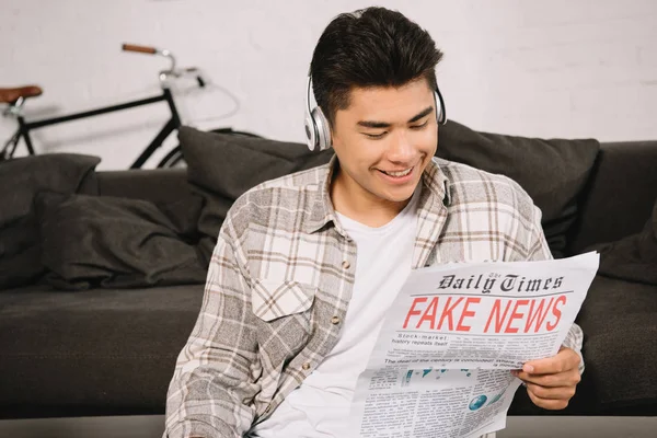 Jeune Asiatique Homme Dans Casque Souriant Tout Lisant Fausses Nouvelles — Photo