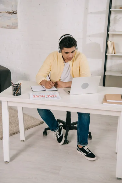 Enfocado Asiático Hombre Auriculares Mirando Portátil Mientras Escribe Portátil — Foto de Stock