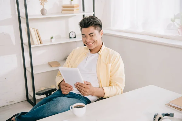 Cheerful Asian Man Looking Digital Tablet While Sitting Desk Cup — Stock Photo, Image
