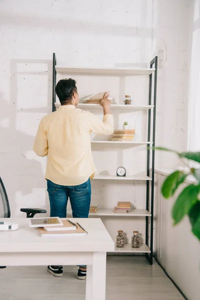 Back View Young Man Standing Rack Books Home — Stock Photo, Image