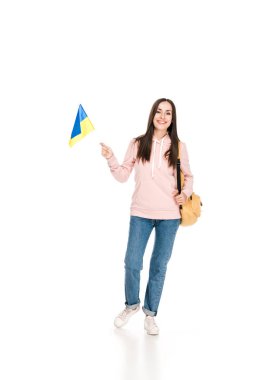 beyaz izole Ukrayna bayrağı tutan sırt çantası ile gülümseyen esmer kız tam uzunlukta görünümü